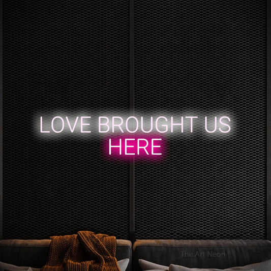 Hot pink and cool white LED neon sign reading "Love Brought Us Here" against a black textured wall for wedding décor