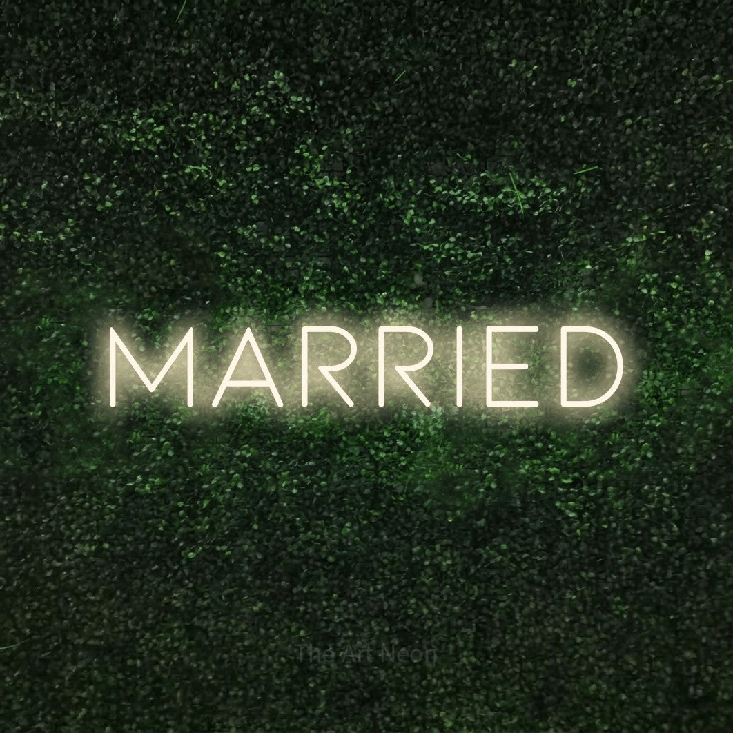 Enseigne néon à DEL à lumière blanche chaude, affichant « Married » sur un mur texturé de mousse verte, pour décorer un mariage