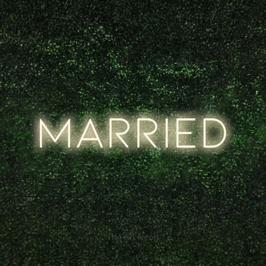 Warm white LED neon sign reading "Married" against a textured green moss wall for wedding décor