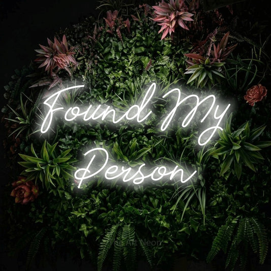 Cool white script-style LED neon sign reading "Found My Person" against a flowering garden wall for wedding décor