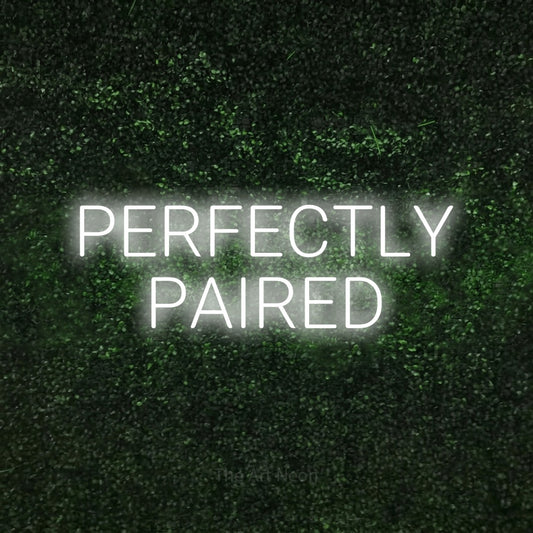 Cool white LED neon sign reading "Perfectly Paired" against a textured green moss wall for wedding décor