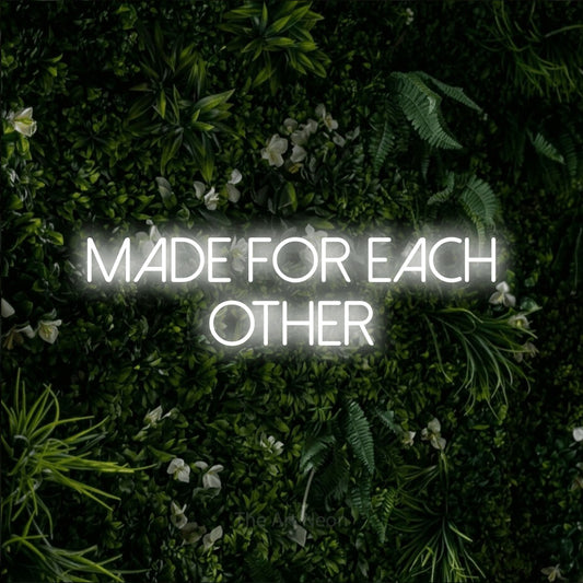 Cool white LED neon sign reading "Made for Each Other" against a leafy green wall for wedding décor