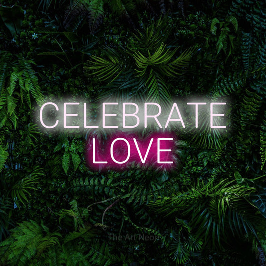 Hot pink and cool white LED neon sign reading "Celebrate Love" against a dense tropical foliage wall for wedding décor