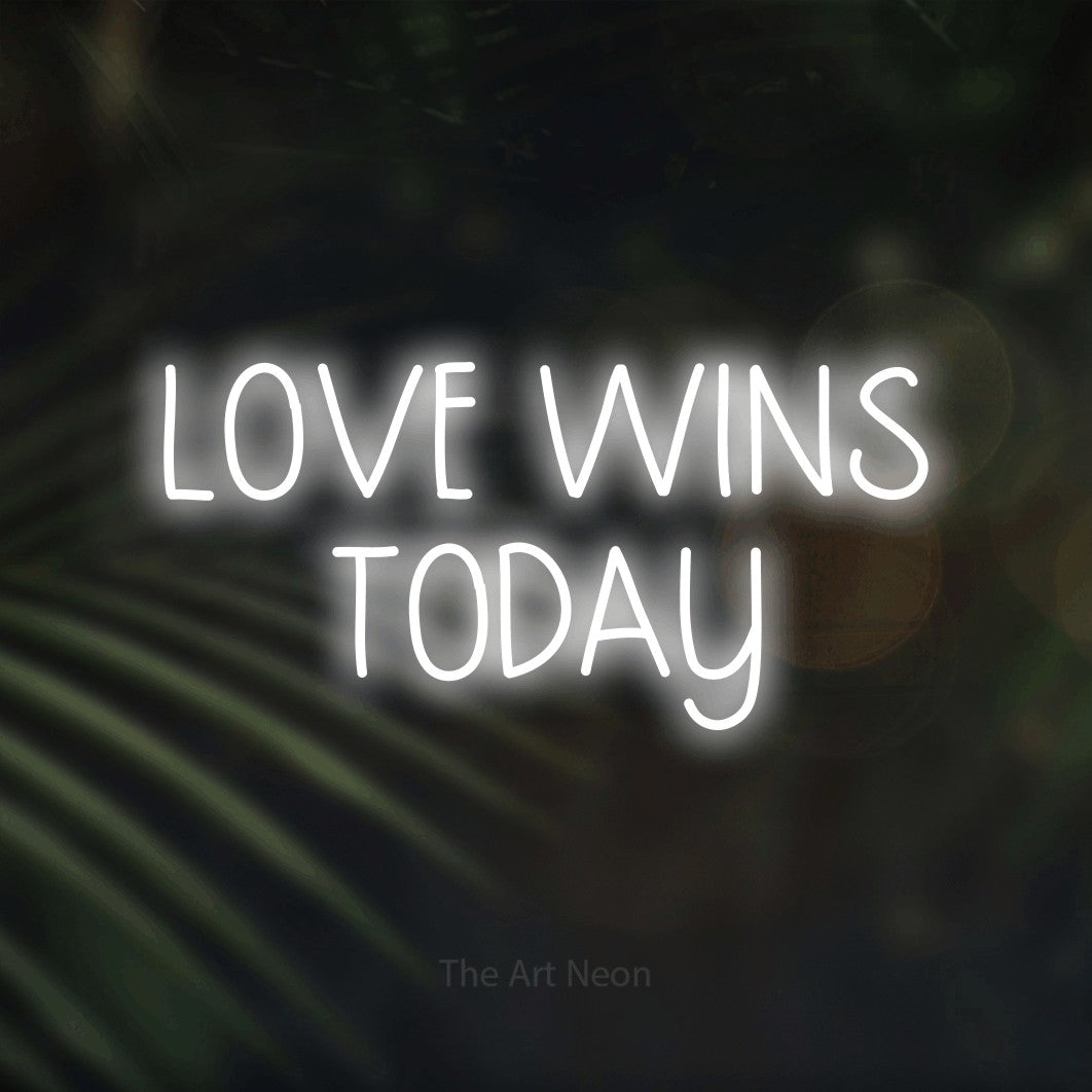 Cool white LED neon sign reading "Love Wins Today" against dark blurred palm leaves for wedding décor