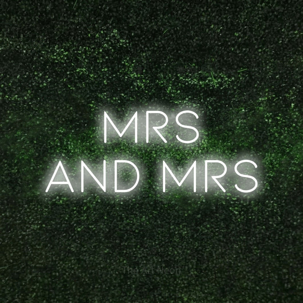 Cool white LED neon sign reading "Mrs and Mrs" against a textured green moss wall for wedding décor