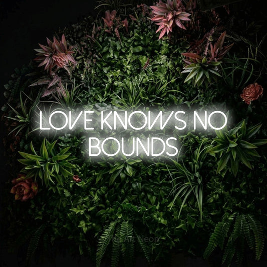 Cool white LED neon sign reading "Love Knows No Bounds" against a flowering garden wall for wedding décor