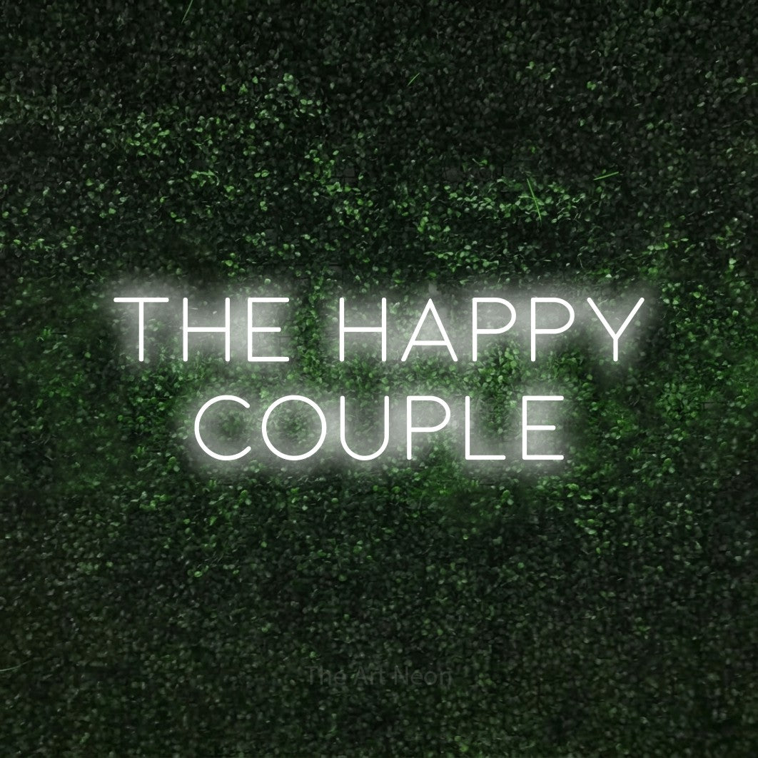 Cool white LED neon sign reading "The Happy Couple" against a textured green moss wall for wedding décor