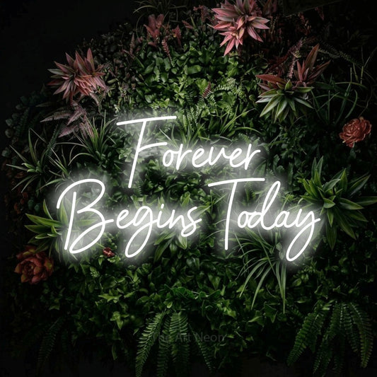 Cool white script-style LED neon sign reading "Forever Begins Today" against a flowering garden wall for wedding décor