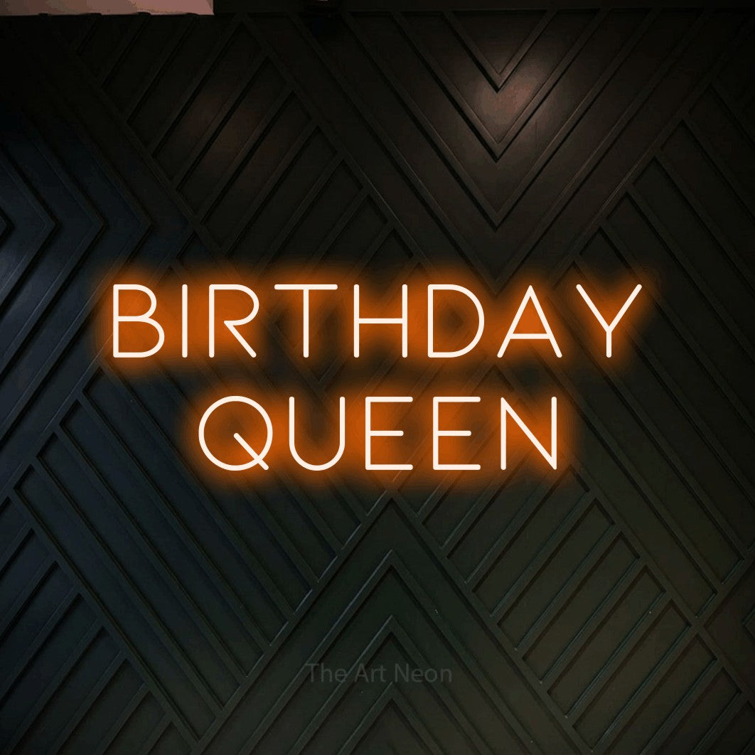 Orange LED neon sign reading "Birthday Queen" against a dark geometric wood wall for party décor