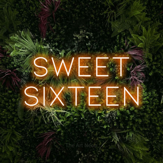 Enseigne néon à DEL à lumière orange, affichant « Sweet Sixteen » sur un mur de jardin luxuriant aux fleurs roses, pour décorer une fête