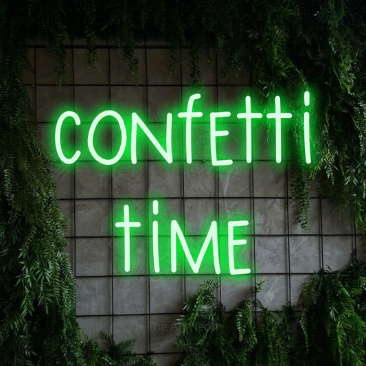 Enseigne néon à DEL à lumière verte, affichant « Confetti Time » sur un mur quadrillé vert avec du feuillage, pour décorer une fête