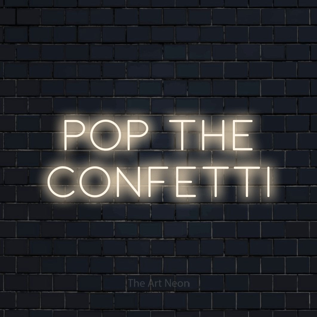 Warm white LED neon sign reading "Pop the Confetti" against a dark navy brick wall for party décor