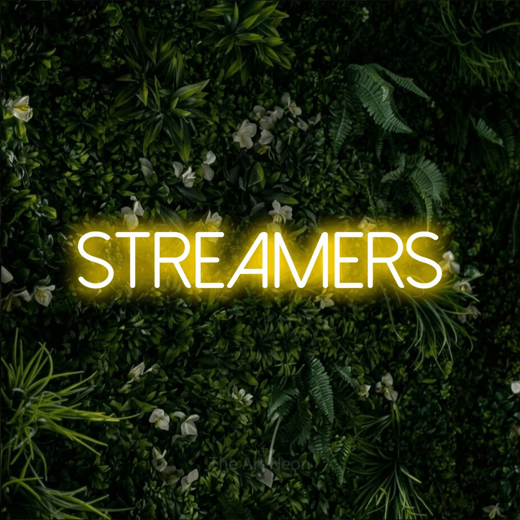 Enseigne néon à DEL à lumière jaune, affichant « Streamers » sur un mur de feuillage vert, pour décorer une fête