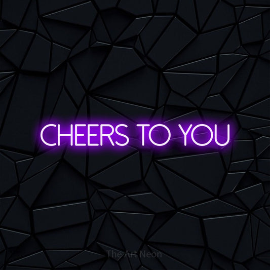 Purple LED neon sign reading "Cheers to You" against a black faceted wall for party décor