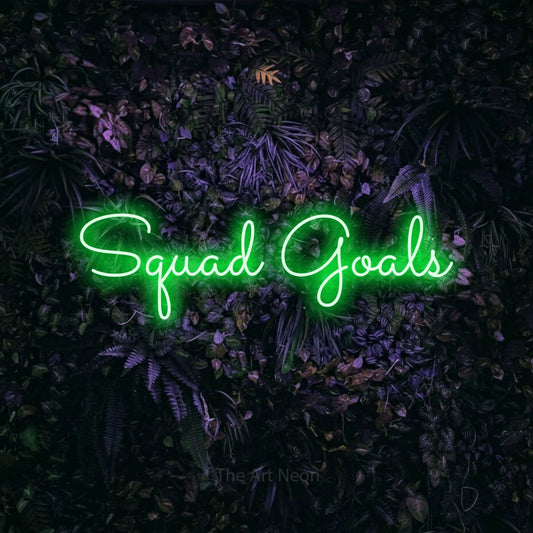Green LED neon sign reading "Squad Goals" against a purple floral wall for party décor