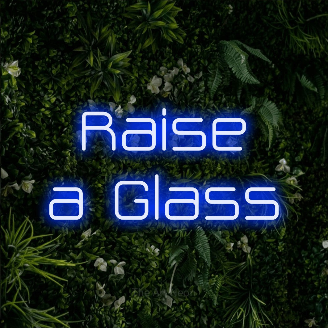 Blue LED neon sign reading "Raise a Glass" against a leafy green wall for party décor