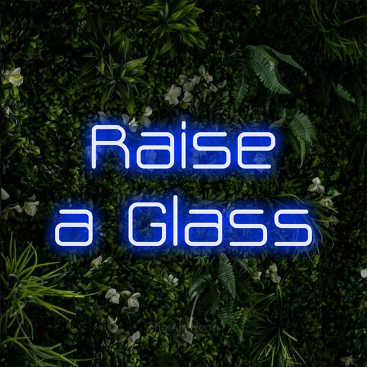 Blue LED neon sign reading "Raise a Glass" against a leafy green wall for party décor