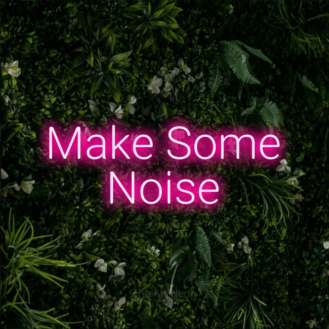 Hot pink LED neon sign reading "Make Some Noise" against a leafy green wall for party décor