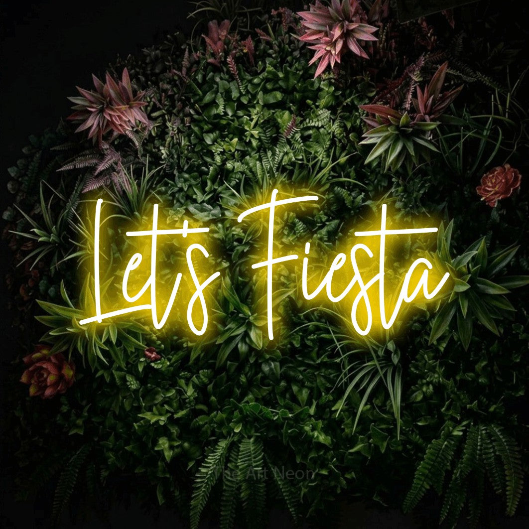 Yellow script-style LED neon sign reading "Let's Fiesta" against a flowering garden wall for party décor