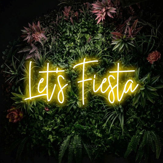 Yellow script-style LED neon sign reading "Let's Fiesta" against a flowering garden wall for party décor