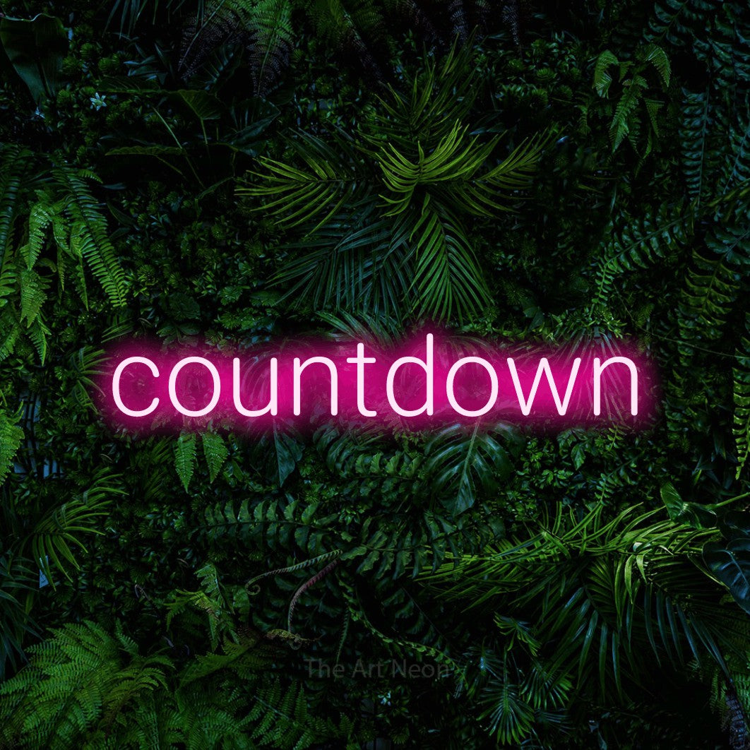 Hot pink LED neon sign reading "Countdown" against a dense tropical foliage wall for party décor
