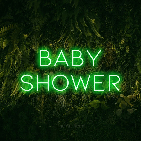 Green LED neon sign reading "Baby Shower" against a moss-covered green wall