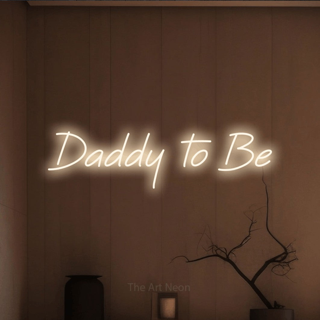 Warm white LED neon sign reading "Daddy to Be" against a warm brown wall