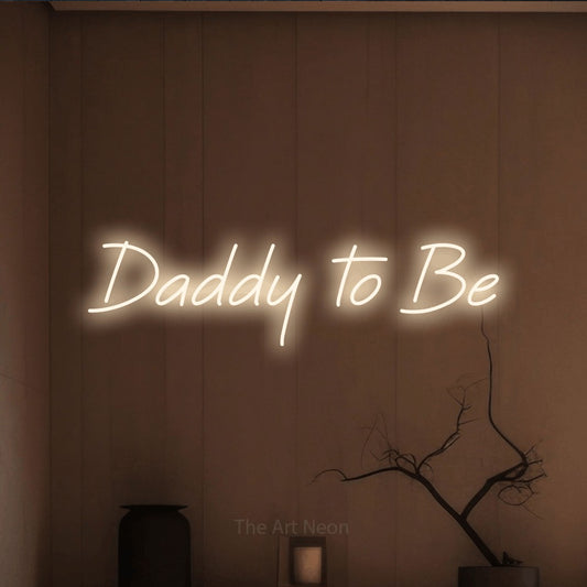 Enseigne néon à DEL à lumière blanche chaude, affichant « Daddy to Be » sur un mur brun chaleureux