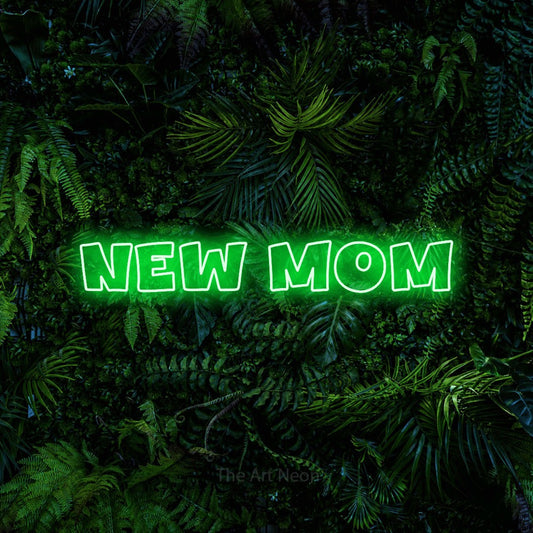 Enseigne néon à DEL à lumière verte, de style contour, affichant « New Mom » sur un mur de feuillage tropical dense