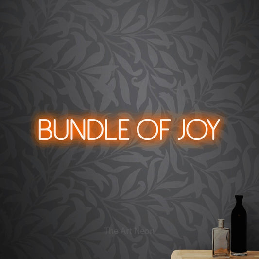 Enseigne néon à DEL à lumière orange, affichant « Bundle of Joy » sur un papier peint floral gris pâle