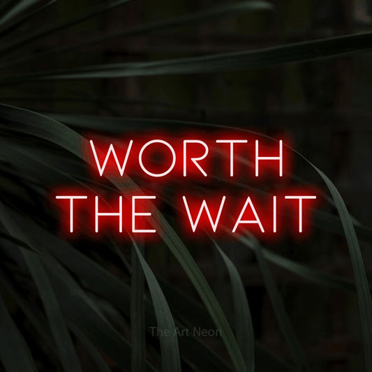Enseigne néon à DEL à lumière rouge, affichant « Worth the Wait » sur des feuilles tropicales foncées