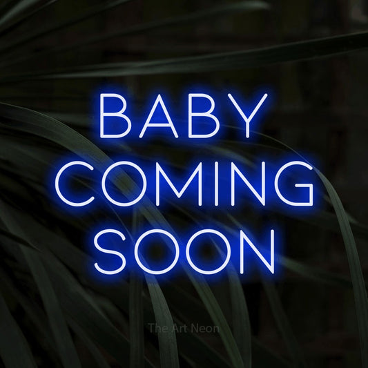 Blue LED neon sign reading "Baby Coming Soon" against dark tropical leaves
