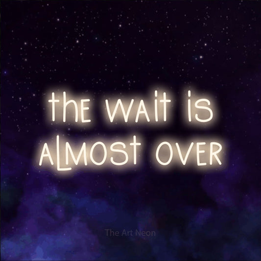 Warm white LED neon sign reading "The Wait is Almost Over" against a purple galaxy background
