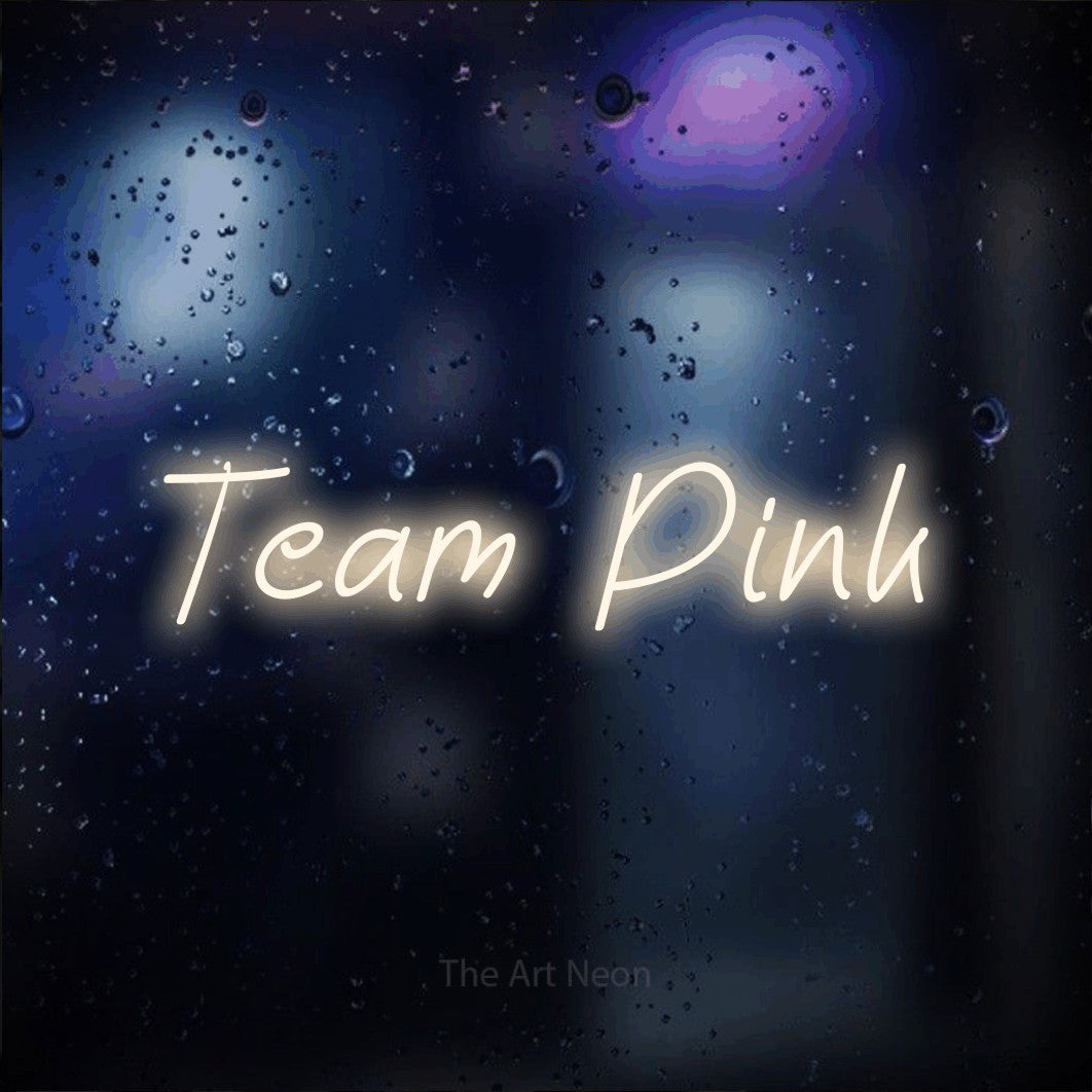 Warm white LED neon sign reading "Team Pink" against a dark blue bokeh background