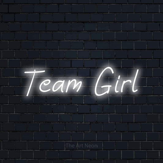 Cool white LED neon sign reading "Team Girl" against a dark navy brick wall
