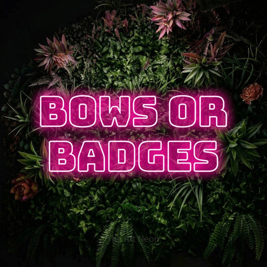 Hot pink outline-style LED neon sign reading "Bows or Badges" against a flowering garden wall