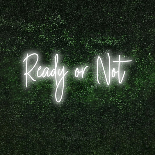 Cool white script-style LED neon sign reading "Ready or Not" against a textured green moss wall
