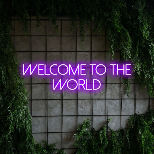 Purple LED neon sign reading "Welcome to the World" against a green grid wall with foliage
