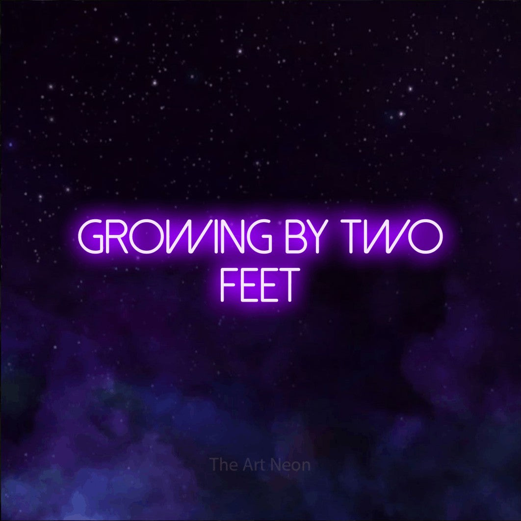Purple LED neon sign reading "Growing by Two Feet" against a purple galaxy background