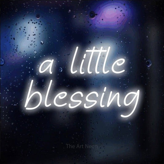Cool white LED neon sign reading "A Little Blessing" against a dark blue bokeh background