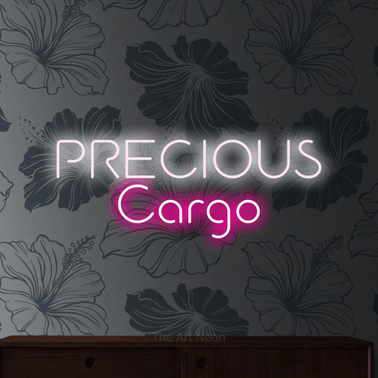 Hot pink and cool white LED neon sign reading "Precious Cargo" against grey floral wallpaper