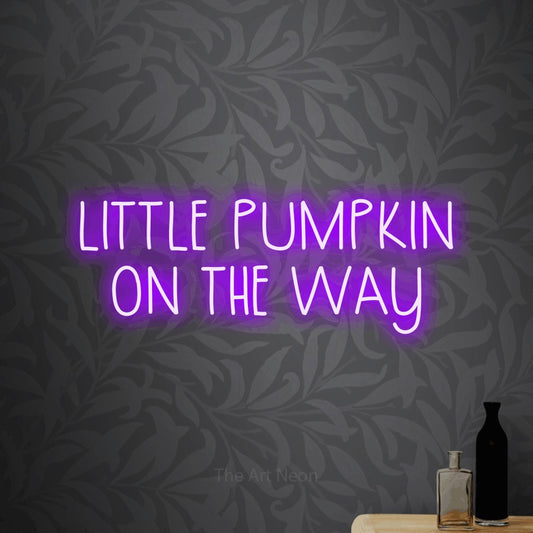 Purple LED neon sign reading "Little Pumpkin on the Way" against light grey floral wallpaper