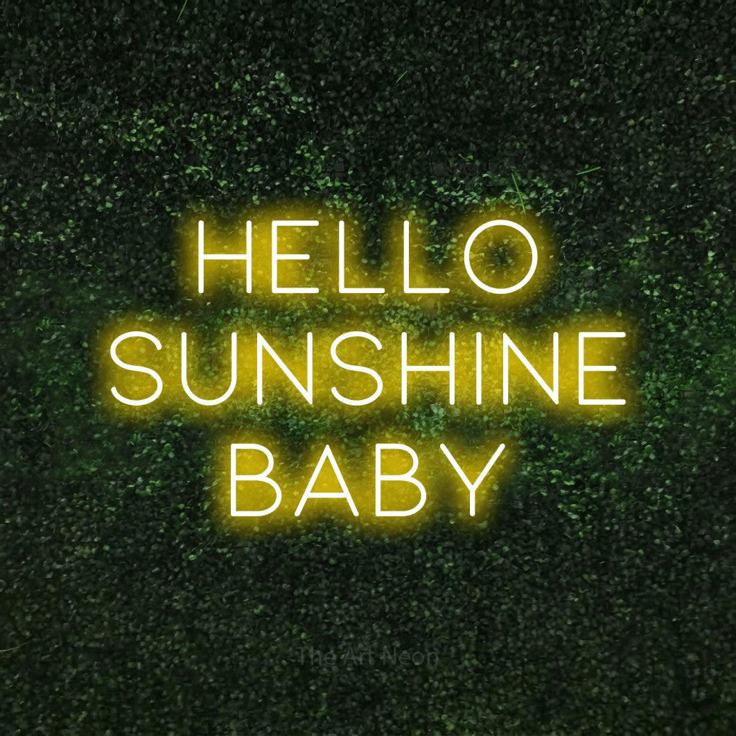 Yellow LED neon sign reading "Hello Sunshine Baby" against a textured green moss wall