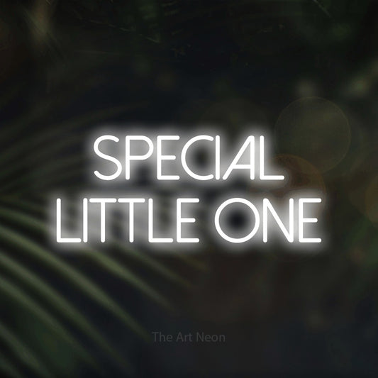 Cool white LED neon sign reading "Special Little One" against dark blurred palm leaves