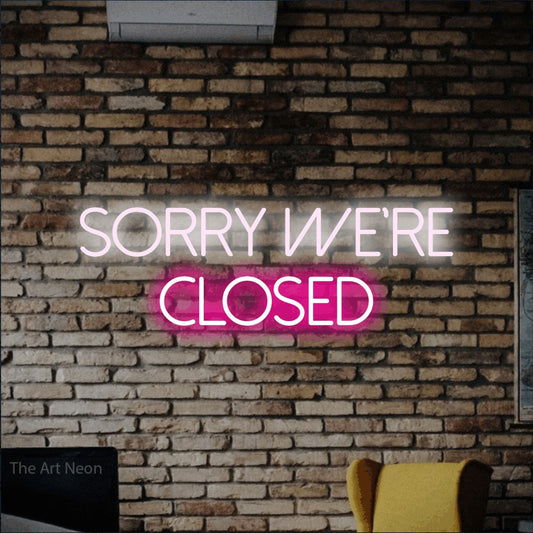 Hot pink and cool white LED neon sign reading "Sorry We're Closed" against a rustic brick wall for restaurant décor
