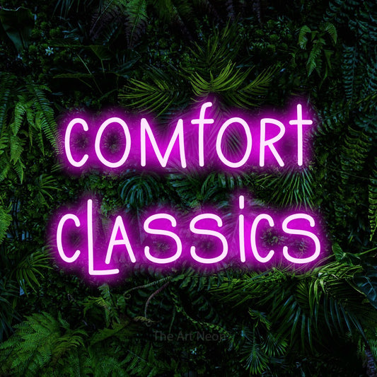 Pink LED neon sign reading "Comfort Classics" against a dense tropical foliage wall for restaurant décor