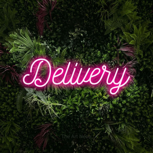 Hot pink script-style LED neon sign reading "Delivery" against a lush garden wall with pink flowers for restaurant décor