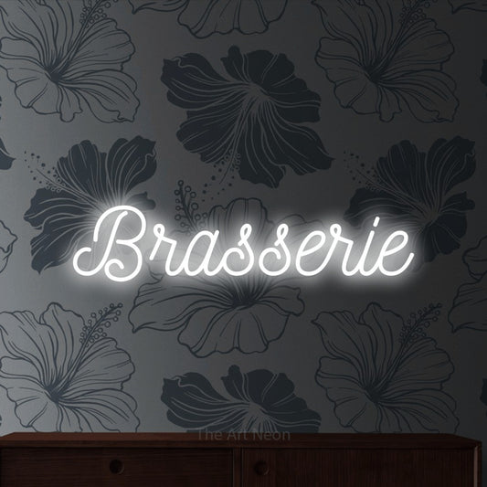 Cool white script-style LED neon sign reading "Brasserie" against grey floral wallpaper for restaurant décor