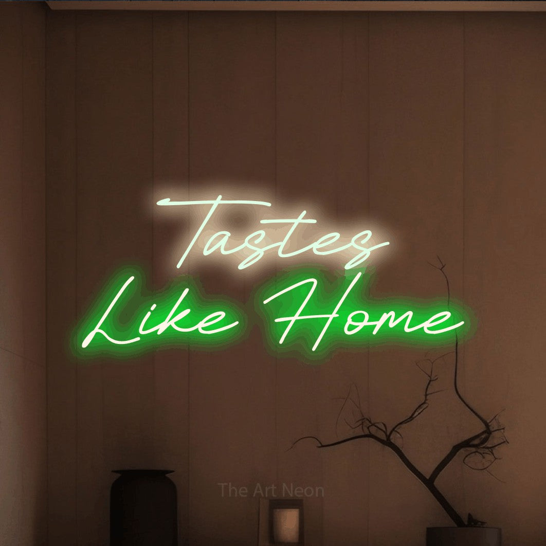 Green and warm white LED neon sign reading "Tastes Like Home" against a warm brown wall for restaurant décor
