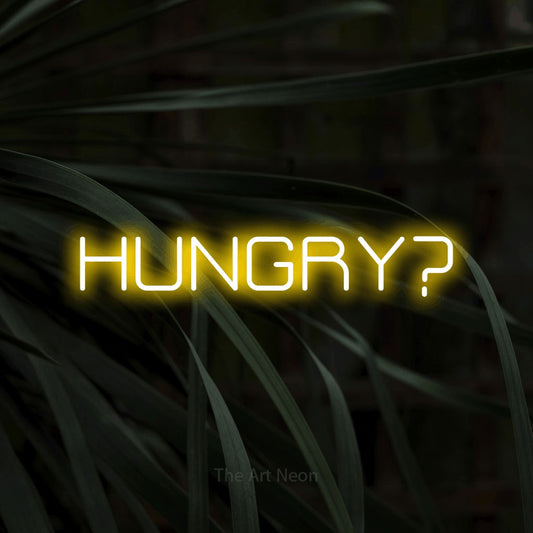 Yellow LED neon sign reading "Hungry?" against dark tropical leaves for restaurant décor